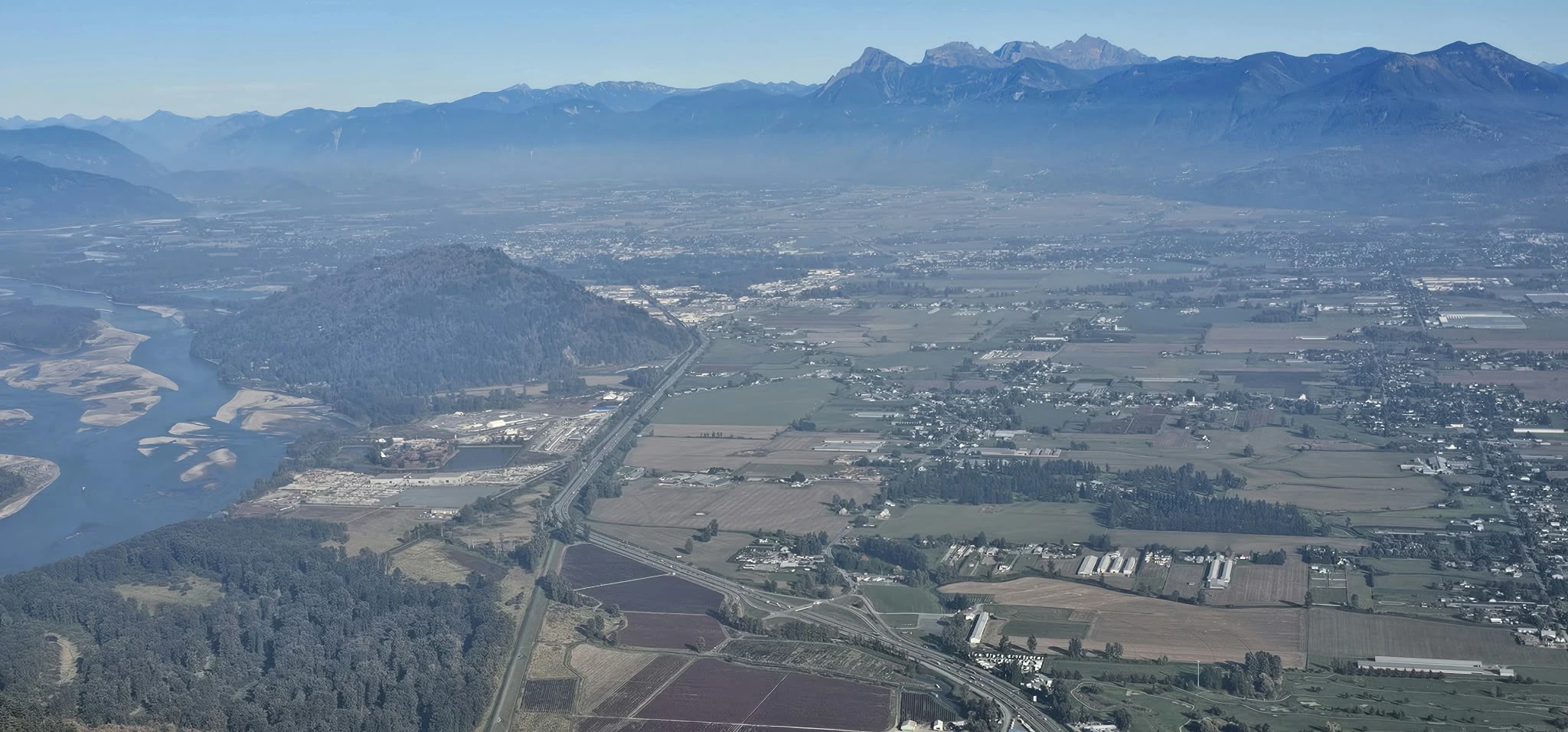 Panoramic view over Chilliwack, Highway 1, Fraser River channels and the Cheam Range from Sumas Mountain